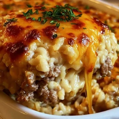 Cheesy ground beef rice casserole baked in a dish, garnished with herbs
