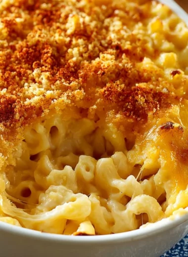 Baked macaroni and cheese with a golden, cheesy crust served in a cozy setting.