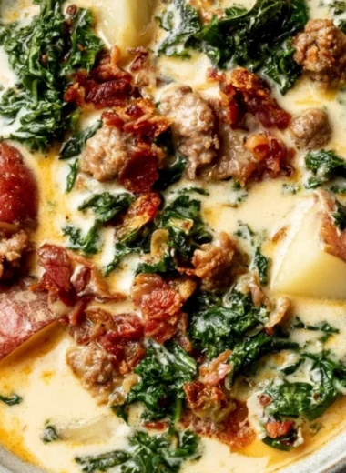 A bowl of creamy Tuscany soup garnished with herbs and vegetables.