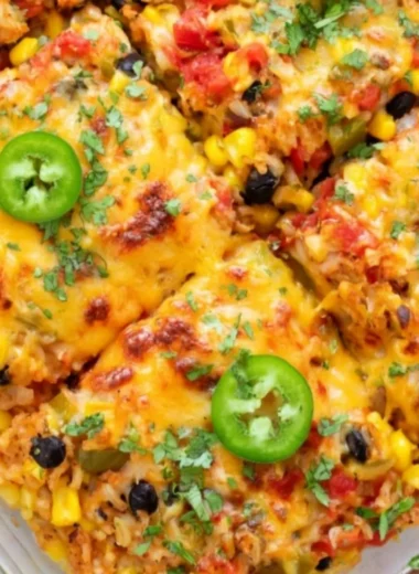 Healthy vegetarian rice and bean casserole baked in a dish, full of colorful vegetables.