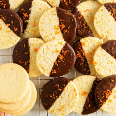 Chocolate dipped orange shortbread cookies on a white plate