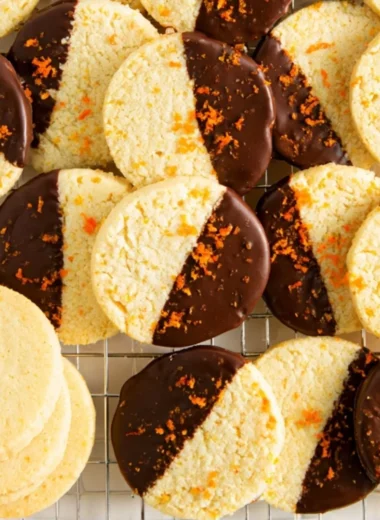 Chocolate dipped orange shortbread cookies on a white plate