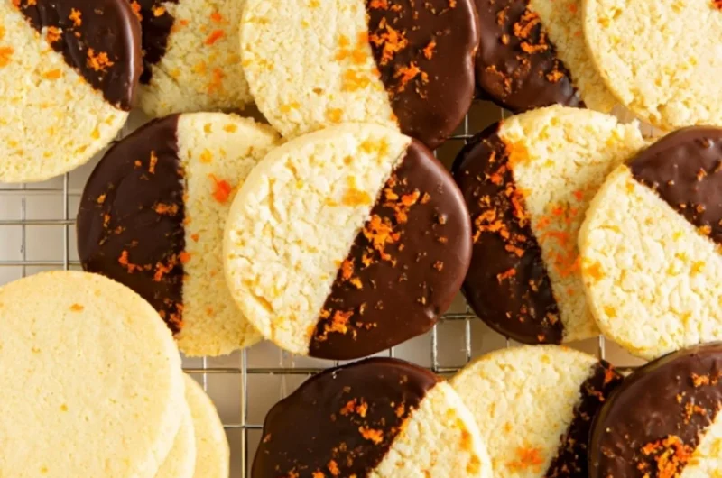 Chocolate dipped orange shortbread cookies on a white plate