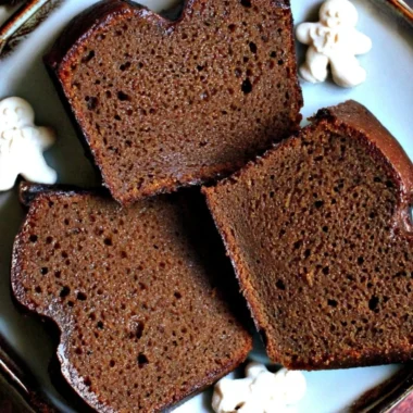 Slice of moist Christmas gingerbread loaf cake topped with icing