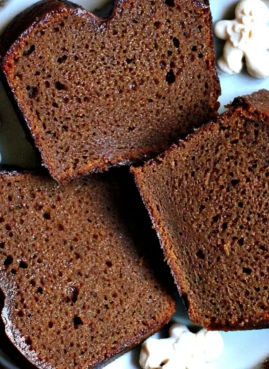 Slice of moist Christmas gingerbread loaf cake topped with icing