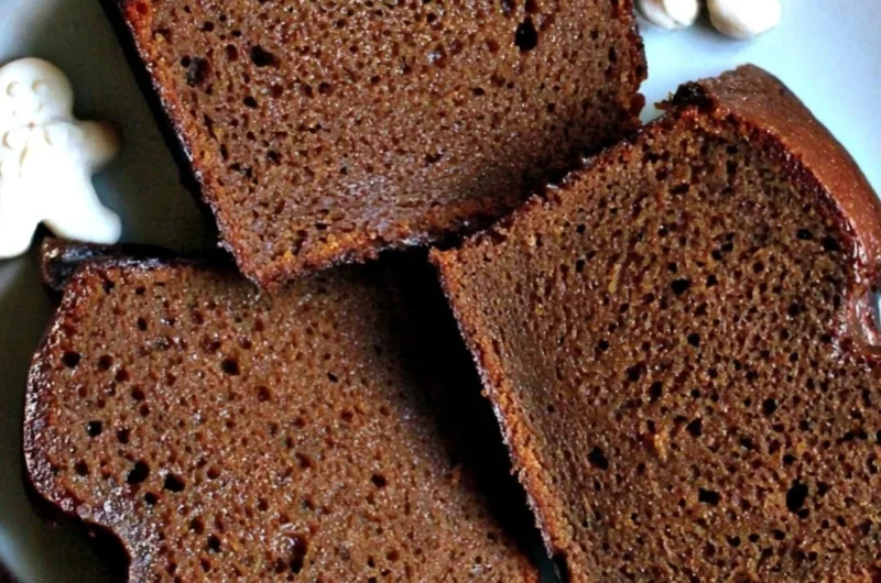 Slice of moist Christmas gingerbread loaf cake topped with icing