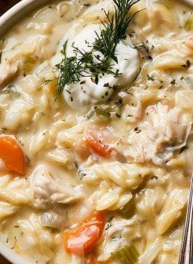 Delicious bowl of creamy chicken orzo soup garnished with herbs